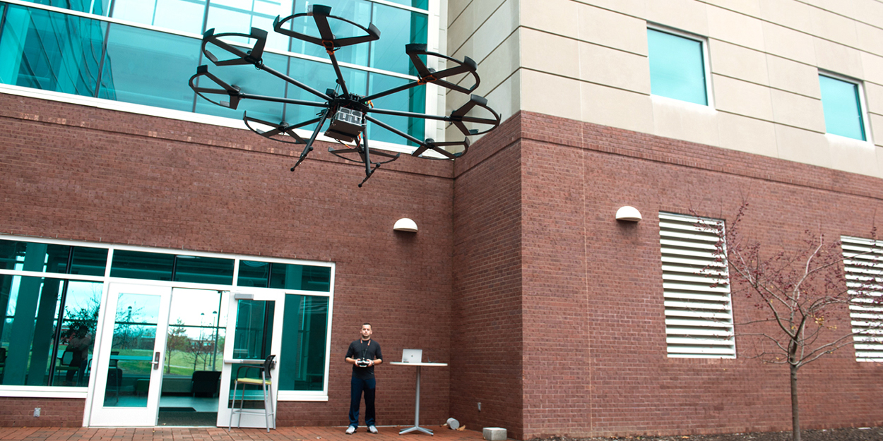 A student flying a drone outside of the Engineering Building at SIUE.