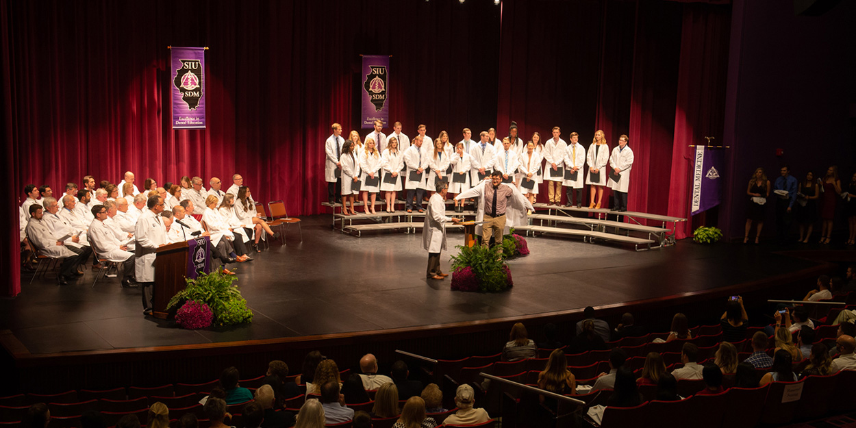 Student receiving there white coats.