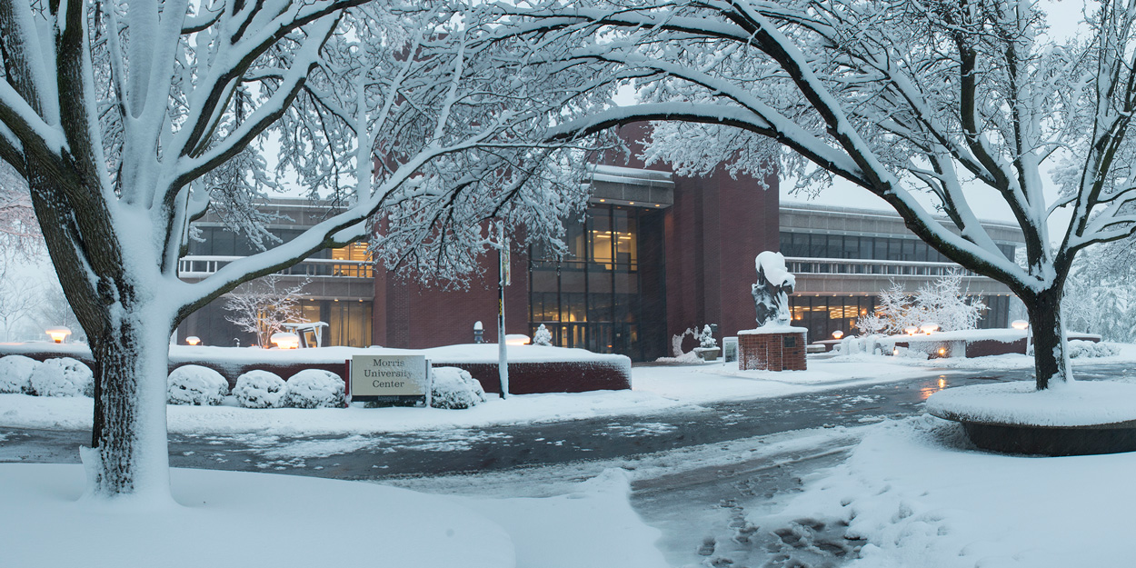 The front of the Morris University Center during the winter covered in snow.