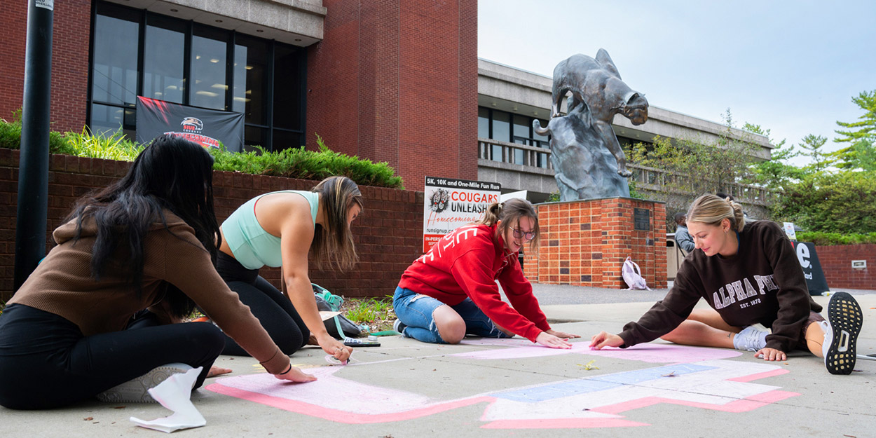 Student at SIUE making chalk art on the Stratton Quadrangle near the MUC.