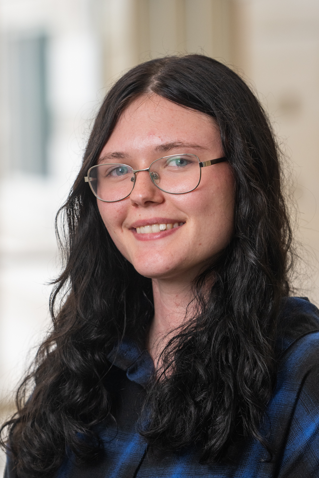 White woman with dark hair and glasses