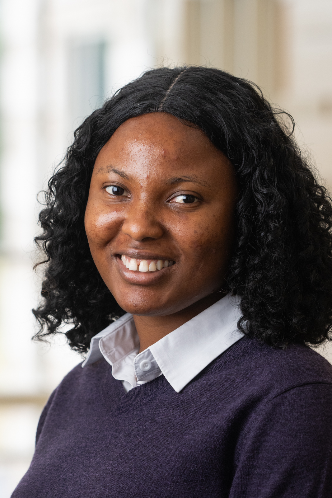 Young Black woman in purple sweater with white collar