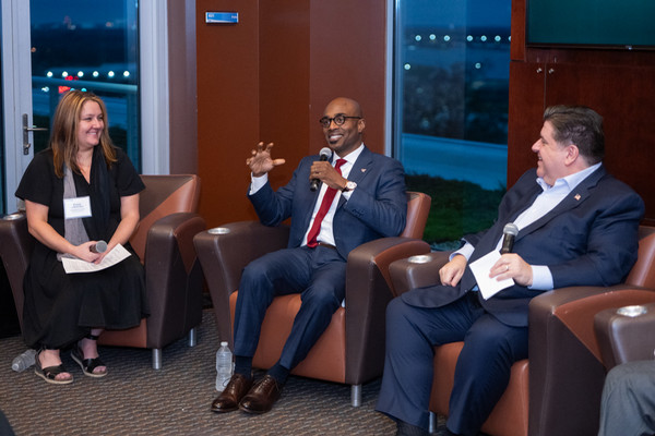 Three people seated with Dr Minor in the middle as he is speaking