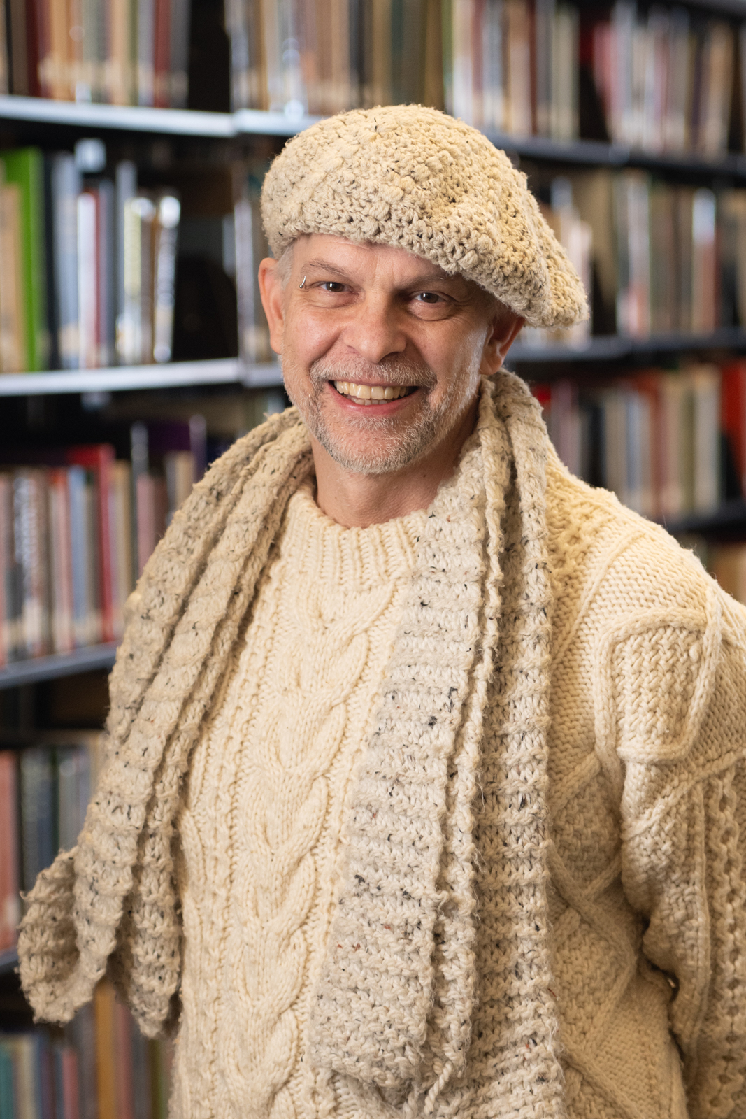 Honors Director Dr. Eric Ruckh pictured in front of library books.