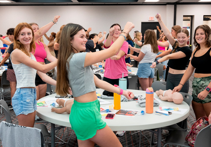 group of students standing and making large hand gestures