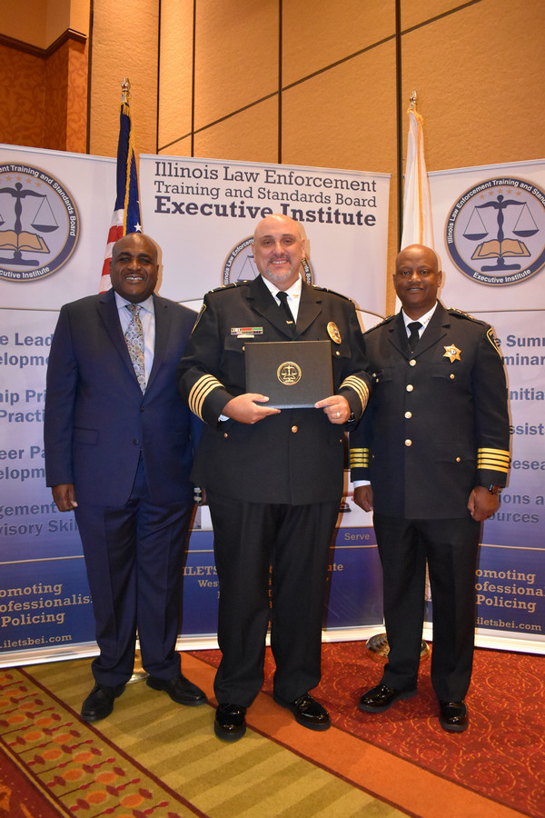 ILETSB Director and two police chiefs pose while holding accreditations 