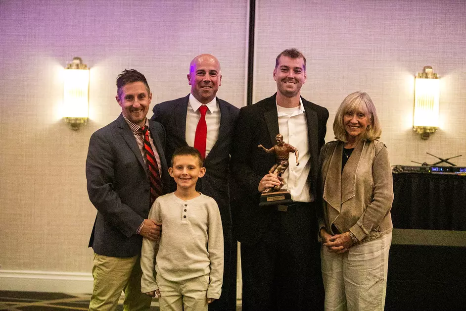 portrait of Jacob Bilyeu with head coach Cale Wasserman and members of the Blake family