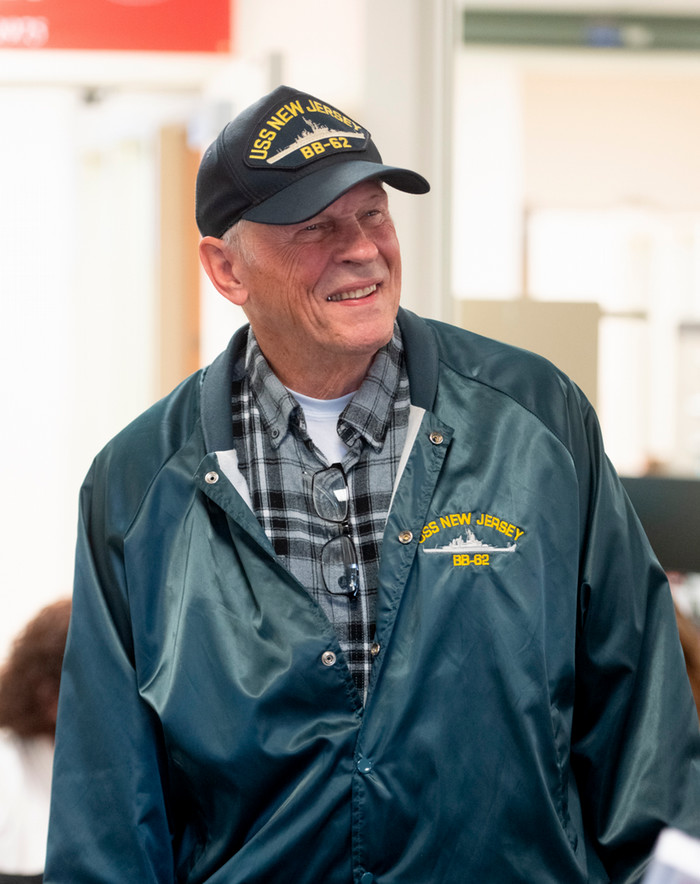 photo of a smiling Jack Nothdurft wearing a USS New Jersey hat and matching navy windbreaker